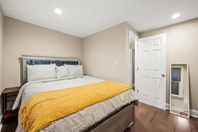 a bedroom with a bed with a yellow blanket at Spacious 3-Bedroom Apt in the Heart of Philly in Philadelphia