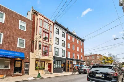 a city street with buildings and cars parked on the street at Spacious 3-Bedroom Apt in the Heart of Philly in Philadelphia