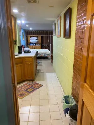 a hallway of a kitchen with a room with a bed at Cozy charming private studio in North Bergen