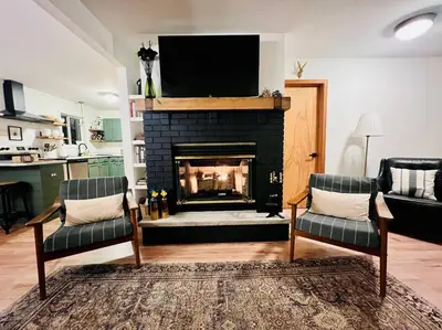 a living room with a fireplace with a flat screen tv at Cozy Cottage by the Lake in Albrightsville