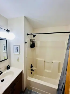 a bathroom with a tub and a sink and a shower at Cozy Cottage by the Lake in Albrightsville