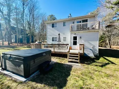 a large white house with a large grill in the yard at Cozy Cottage by the Lake in Albrightsville