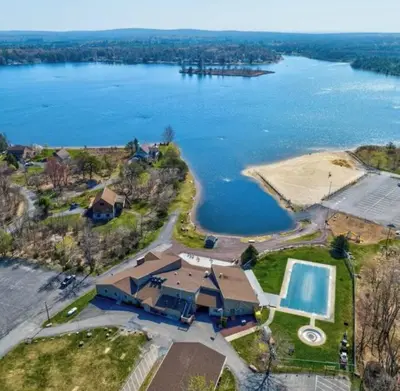 an aerial view of a large house with a swimming pool at Cozy Cottage by the Lake in Albrightsville