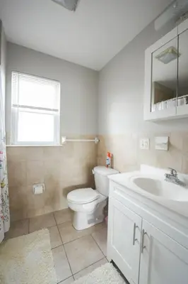 a white bathroom with a toilet and a sink at Newark Liberty Brick House - Private Bedroom 1 in Newark