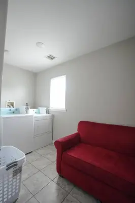 a living room with a red couch and a sink at Newark Liberty Brick House - Private Bedroom 2 in Newark