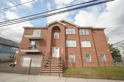 a red brick house with a white door at Newark Liberty Brick House - Private Bedroom 2 in Newark