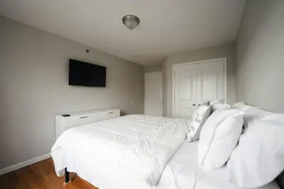 a white bed with white sheets and pillows in a bedroom at Newark Liberty Brick House - Private Bedroom 3 in Newark