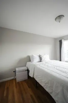 a white bedroom with a bed and a window at Newark Liberty Brick House - Private Bedroom 3 in Newark