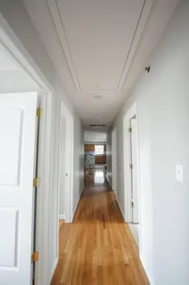 an empty hallway with white walls and wood floors at Newark Liberty Brick House - Private Bedroom 4 in Newark