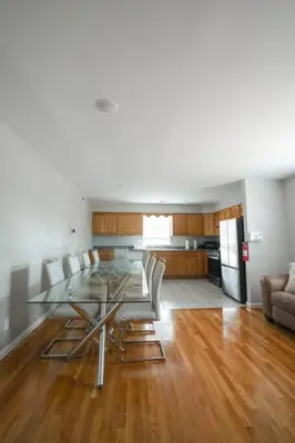 a dining room and kitchen with a glass table and chairs at Newark Liberty Brick House - Private Bedroom 4 in Newark