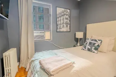 a bedroom with a bed with a pillow and a window at Stylish 3Bd in Manhattan near the Empire State Building in New York
