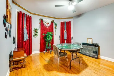 a dining room with a glass table and red curtains at 15 Mi to NYC Apartment in Newark in Newark