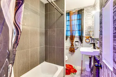 a bathroom with a white tub and a sink at 15 Mi to NYC Apartment in Newark in Newark
