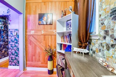 a room with a wooden door and a book shelf at 15 Mi to NYC Apartment in Newark in Newark