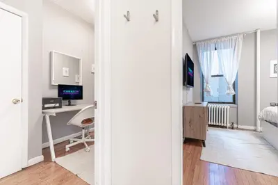 a bedroom with a bed and a desk with a computer at Charming 3Bd in Manhattan in New York