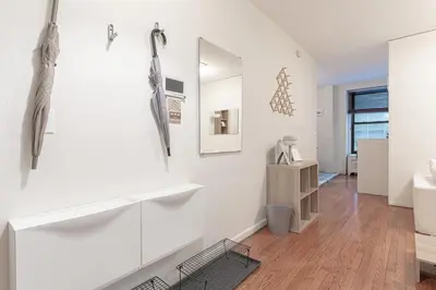 a living room with white walls and wooden floors at Charming 3Bd in Manhattan in New York