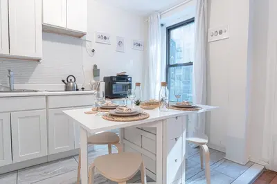 a kitchen with a table with plates and glasses on it at Charming 3Bd in Manhattan in New York