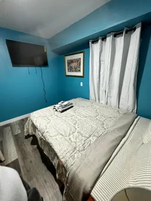 a bedroom with a bed with a blue wall at A Temporary Haven in Newark