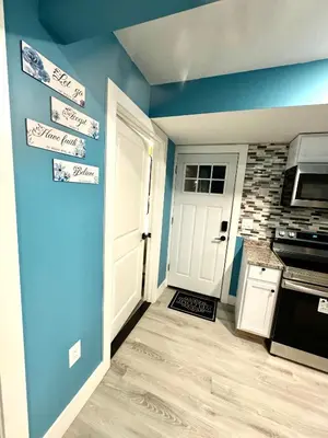 a room with a door and a kitchen with signs on the wall at A Temporary Haven in Newark