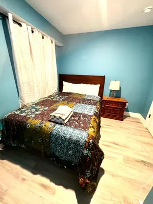 a bedroom with a bed with a quilt on it at A Temporary Haven in Newark
