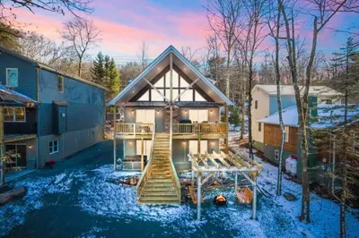 a house with a playground in the yard at New Luxury Lakeview Retreat with Lake Access, HotTub, Game Room, Sleeps 28 in Lake Harmony