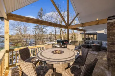 an outdoor patio with a table and chairs and a grill at New Luxury Lakeview Retreat with Lake Access, HotTub, Game Room, Sleeps 28 in Lake Harmony