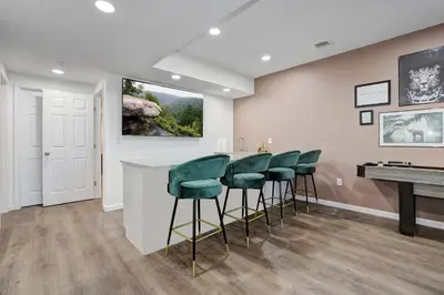 a bar with green bar stools in a waiting room at New Luxury Lakeview Retreat with Lake Access, HotTub, Game Room, Sleeps 28 in Lake Harmony