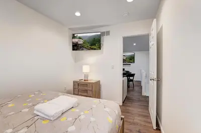 a white bedroom with a bed and a desk and a door at New Luxury Lakeview Retreat with Lake Access, HotTub, Game Room, Sleeps 28 in Lake Harmony