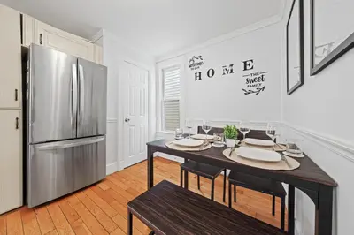 a kitchen with a table and a refrigerator at Stylish Apartment - Light Rail Access in Bayonne