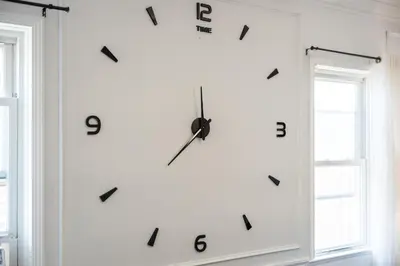 a clock on a wall next to two windows at Stylish Apartment - Light Rail Access in Bayonne