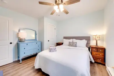 a bedroom with a white bed and a ceiling fan at Arrowhead Lake Access and Fire Pit Serene Cottage in Pocono Lake