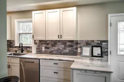 a kitchen with white cabinets and a counter top at Arrowhead Lake Access and Fire Pit Serene Cottage in Pocono Lake