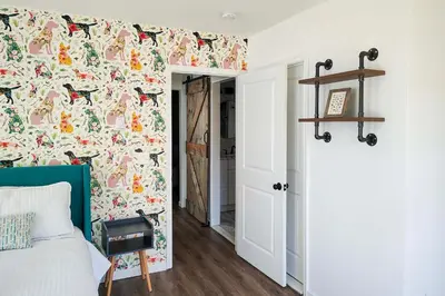 a bedroom with a bed with a floral wallpaper at Arrowhead Lake Access and Fire Pit Serene Cottage in Pocono Lake