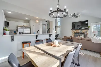 a dining room and living room with a table and chairs at 1 Mi to Waterpark Mtn-View Poconos Hideaway! in Tannersville
