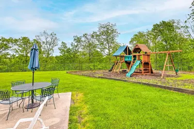 a playground with a table and chairs and an umbrella at 1 Mi to Waterpark Mtn-View Poconos Hideaway! in Tannersville