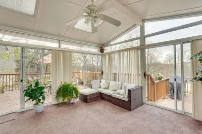 a screened in porch with a couch and a ceiling fan at Monroe Home Near LEGOland and State Parks! in Monroe