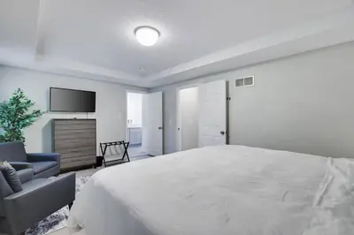 a white bedroom with a large bed and a tv at Cozy Poconos Retreat Hot tub, Game room and igloo in Tobyhanna