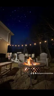 a fire pit in the middle of a backyard at night at Cozy Poconos Retreat Hot tub, Game room and igloo in Tobyhanna