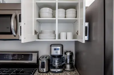 a kitchen with white cabinets and a coffee maker at Blueground UWS gym elevator nr Central Park NYC-1443 in New York