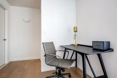 a desk with a laptop and a chair in a room at Blueground UWS gym elevator nr Central Park NYC-1443 in New York