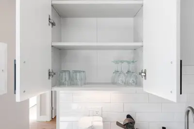 a kitchen with white cabinets and glass vases at Stunning 1-BD - City Views - Near Fishtown in Philadelphia