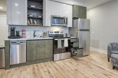 a kitchen with stainless steel appliances and wooden floors at One Sky Loft in Philadelphia