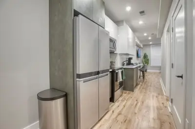 a kitchen with a stainless steel refrigerator and wooden floors at One Sky Loft in Philadelphia