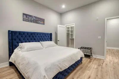 a bedroom with a large bed with a blue headboard at One Sky Loft in Philadelphia