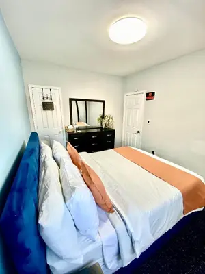 a bedroom with a large bed with a blue couch at Private Room C West NY, NJ 12 mints from NYCity Times Square in West New York