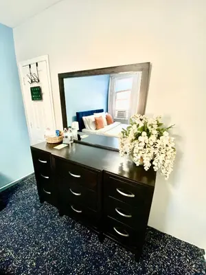 a bathroom vanity with a large mirror and flowers on it at Private Room C West NY, NJ 12 mints from NYCity Times Square in West New York