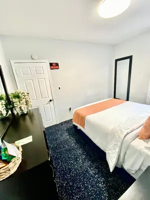 a bedroom with a bed and a table and a door at Private Room C West NY, NJ 12 mints from NYCity Times Square in West New York