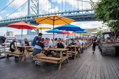 a group of people sitting at tables with umbrellas at Near Fishtown and Old City - King Bed - City Views in Philadelphia