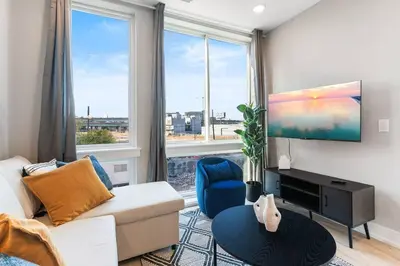 a living room with a couch and a large window at Waterfront Studio - Near Fishtown and Old City in Philadelphia