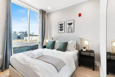 a bedroom with a large bed and a large window at Waterfront Studio - Near Fishtown and Old City in Philadelphia